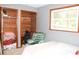 Bedroom showcases well-organized closet space and a comfortable chair with natural light from the windows at 16536 Caldwell Ln, Spring Hill, FL 34610