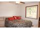 Bedroom features natural light from the window, enhancing the cozy atmosphere and neutral color palette at 16536 Caldwell Ln, Spring Hill, FL 34610