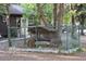 Small enclosed chicken coop with protective fencing and trees at 16536 Caldwell Ln, Spring Hill, FL 34610