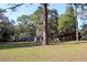 Spacious front yard with mature trees and outbuildings, perfect for enjoying the natural surroundings at 16536 Caldwell Ln, Spring Hill, FL 34610