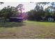 Overview of the front yard showcasing outbuildings, outdoor seating, and plenty of room to entertain at 16536 Caldwell Ln, Spring Hill, FL 34610