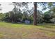 Expansive front yard featuring mature trees, outbuildings, and room to enjoy the outdoors at 16536 Caldwell Ln, Spring Hill, FL 34610