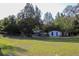 Landscaped front yard with outbuildings, offering ample space for outdoor activities and relaxation at 16536 Caldwell Ln, Spring Hill, FL 34610