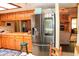 Kitchen with stainless steel refrigerator and wood cabinetry, open to adjacent living area with fireplace at 16536 Caldwell Ln, Spring Hill, FL 34610