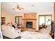 Spacious living room featuring a stone fireplace, ceiling fan, and comfortable seating area at 16536 Caldwell Ln, Spring Hill, FL 34610