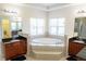 Luxurious primary bathroom featuring a soaking tub, dual vanities, and natural light at 16637 Ashton Green Dr, Lutz, FL 33558