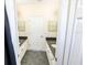 Bathroom includes dual sinks with black countertops and white cabinetry and gray tile flooring at 16637 Ashton Green Dr, Lutz, FL 33558