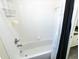 Bright tiled bathtub with white tile and a black shower curtain at 16637 Ashton Green Dr, Lutz, FL 33558
