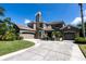 Stately home features a stone chimney, two-car garage, and circular driveway at 16637 Ashton Green Dr, Lutz, FL 33558