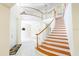 Grand foyer with curved staircase, white railing, and tile flooring at 16637 Ashton Green Dr, Lutz, FL 33558
