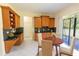 Bright eat-in kitchen area boasts granite counters, wood cabinets, tile floor, and sliding glass doors at 16637 Ashton Green Dr, Lutz, FL 33558