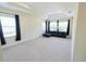 Bright living room with a tray ceiling, plush blue sofa and large windows at 16637 Ashton Green Dr, Lutz, FL 33558