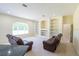 Spacious living room with built-in shelving, recessed lighting, and comfortable leather seating at 16637 Ashton Green Dr, Lutz, FL 33558