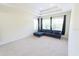 Spacious living room with a tray ceiling, plush blue sofa and large windows at 16637 Ashton Green Dr, Lutz, FL 33558