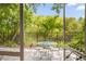 Outdoor patio with dining table and seating, surrounded by lush landscaping and a black fence at 1750 Arabian Ln, Palm Harbor, FL 34685