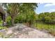 Outdoor patio with dining table and seating, surrounded by lush landscaping at 1750 Arabian Ln, Palm Harbor, FL 34685