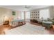 Cozy bedroom with natural light, ceiling fan, warm wood floors, and a colorful bedspread at 1750 Arabian Ln, Palm Harbor, FL 34685