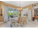 Bright dining area with a view to the outdoor patio, a stylish chandelier, and ample seating at 1750 Arabian Ln, Palm Harbor, FL 34685