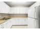 Clean kitchen with plenty of white cabinetry and neutral countertops at 1750 Arabian Ln, Palm Harbor, FL 34685