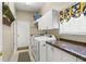 Functional laundry room featuring washer, dryer, granite countertop, storage cabinets and a window at 1750 Arabian Ln, Palm Harbor, FL 34685