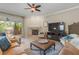 Cozy living room with a fireplace, comfortable seating, and large windows at 1750 Arabian Ln, Palm Harbor, FL 34685