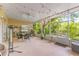 Relaxing screened patio with stylish wicker furniture, ceiling fan, and lush backyard views with string lights at 1750 Arabian Ln, Palm Harbor, FL 34685