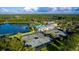 Aerial view of community amenities: tennis courts, pool, clubhouse and lake surrounded by lush greenery at 19453 Sheltered Hill Dr, Brooksville, FL 34601