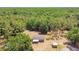 Aerial view showcasing a charming home with a green roof surrounded by lush forest at 19708 Bower Rd, Dade City, FL 33523