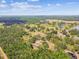 Expansive property aerial featuring a house, barns, lakes, and lush forests at 19708 Bower Rd, Dade City, FL 33523