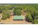 Spacious barn with green metal roof surrounded by lush greenery and trees at 19708 Bower Rd, Dade City, FL 33523