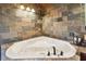 Corner soaking tub featuring slate style stone surround and modern fixtures beneath recessed lighting at 19708 Bower Rd, Dade City, FL 33523