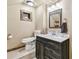 Bathroom with dark wood vanity, white countertop, tile floor, framed mirror and wall lighting at 19708 Bower Rd, Dade City, FL 33523