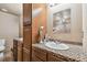 Bathroom vanity with dual sinks, wood cabinets and accent mirror at 19708 Bower Rd, Dade City, FL 33523