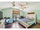 Bedroom with light teal walls, wood floors and natural light from the window at 19708 Bower Rd, Dade City, FL 33523