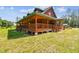 Beautiful log cabin with a wrap-around porch, providing ample outdoor space and a scenic view of the surrounding landscape at 19708 Bower Rd, Dade City, FL 33523