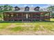 Rustic log cabin showcasing a generous covered porch, offering an ideal spot for relaxation and enjoying the natural surroundings at 19708 Bower Rd, Dade City, FL 33523