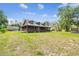 Sprawling log home featuring a welcoming front porch and scenic views of the lush, green landscape surrounding the property at 19708 Bower Rd, Dade City, FL 33523