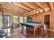 A game room with wood floors, a pool table, wood walls and wood ceiling at 19708 Bower Rd, Dade City, FL 33523