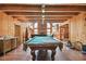 A game room with wood floors, a pool table, wood walls and wood ceiling at 19708 Bower Rd, Dade City, FL 33523