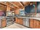 Charming kitchen features stainless steel appliances, wooden cabinets, and a tile backsplash, combining rustic charm with modern amenities at 19708 Bower Rd, Dade City, FL 33523