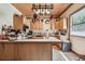 Kitchen with wood cabinets, tile countertops, hanging pot rack and stainless-steel appliances at 19708 Bower Rd, Dade City, FL 33523