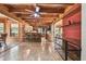 Open-concept living area featuring exposed wooden beams, tile flooring, and a stone-accented bar, creating a rustic and modern feel at 19708 Bower Rd, Dade City, FL 33523
