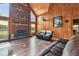 Inviting living room featuring a stone fireplace, hardwood floors, and comfortable seating, creating a cozy and relaxing space at 19708 Bower Rd, Dade City, FL 33523