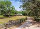 Gated driveway to a beautiful log cabin and green barn on an expansive property at 19708 Bower Rd, Dade City, FL 33523
