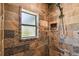 Shower with slate style stone tiling, with rainfall shower head and a built-in niche for storage at 19708 Bower Rd, Dade City, FL 33523