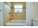 Bright bathroom showcasing tiled bathtub, shower curtain, and window offering natural light at 211 80Th N Ave, St Petersburg, FL 33702