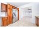Bright kitchen with stainless steel refrigerator, wood cabinets, tile backsplash, and open access to the living room at 211 80Th N Ave, St Petersburg, FL 33702