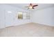 Bright living room with tile flooring, a ceiling fan, and a window allowing natural light to fill the space at 211 80Th N Ave, St Petersburg, FL 33702
