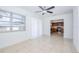 Bright living room with tile floors, ceiling fan, large windows, and an open view to the kitchen at 211 80Th N Ave, St Petersburg, FL 33702