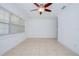 Spacious living area with tile flooring, a ceiling fan, and a large window at 211 80Th N Ave, St Petersburg, FL 33702